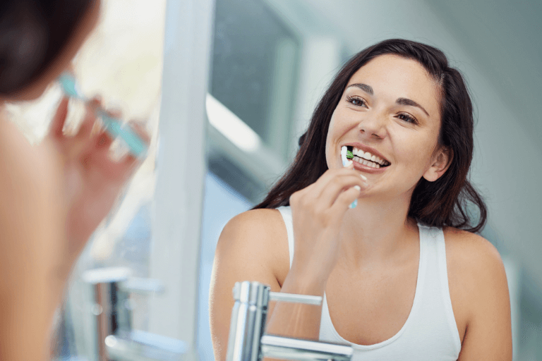 Woman with good oral hygiene brushing her teeth in Bolton, Harwood