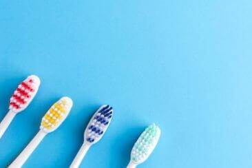 coloured toothbrushes on blue background