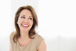 Cheerful mature woman looking away isolated over white background