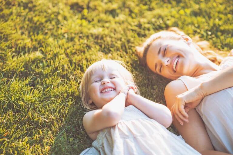 Mother and young daughter smiling