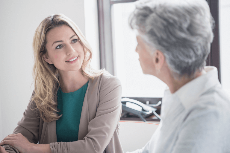 Two women talking with tooth implants at Bolton dental practice