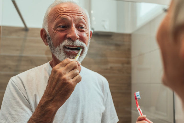 Man with dental implants in Bolton, Harwood brushing his teeth