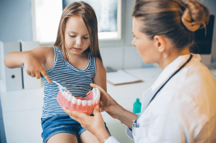 small girl brushing fake teeth at Harwood Dental Care - Bolton, Harwood