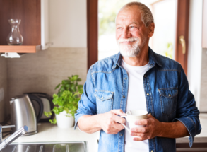 man in his kitchen thinking about different dental implants